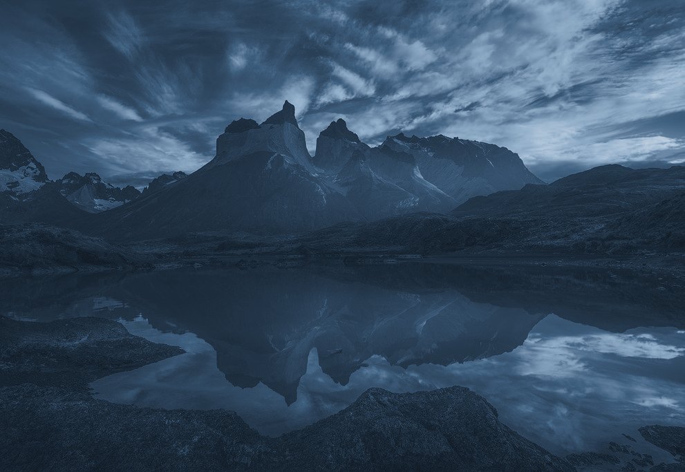 The Cuernos del Paine reflected in a lake at sunset