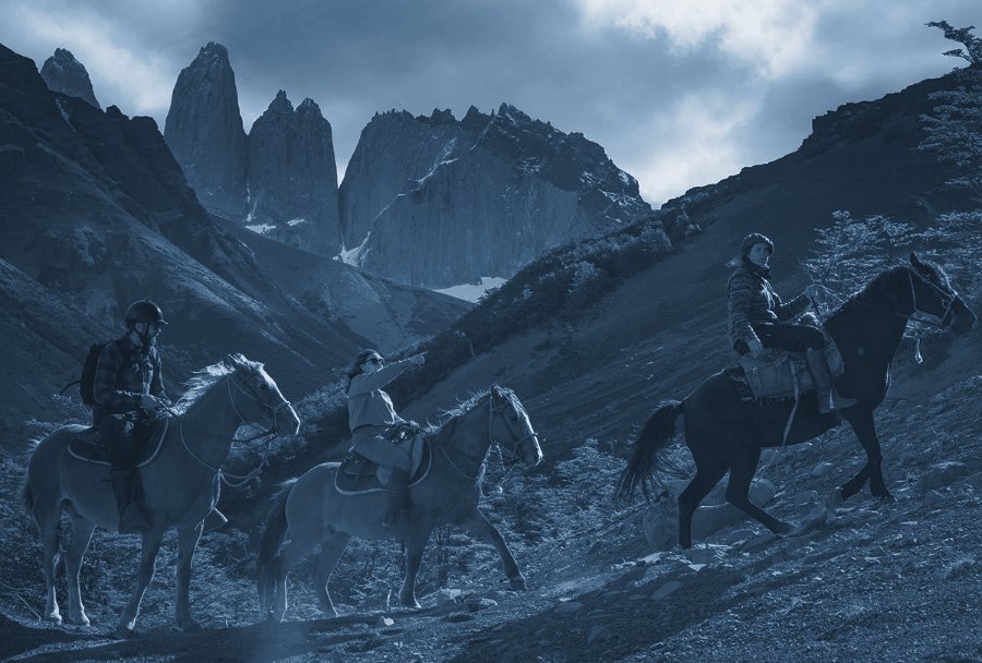 Riders on horseback below the Paine massif